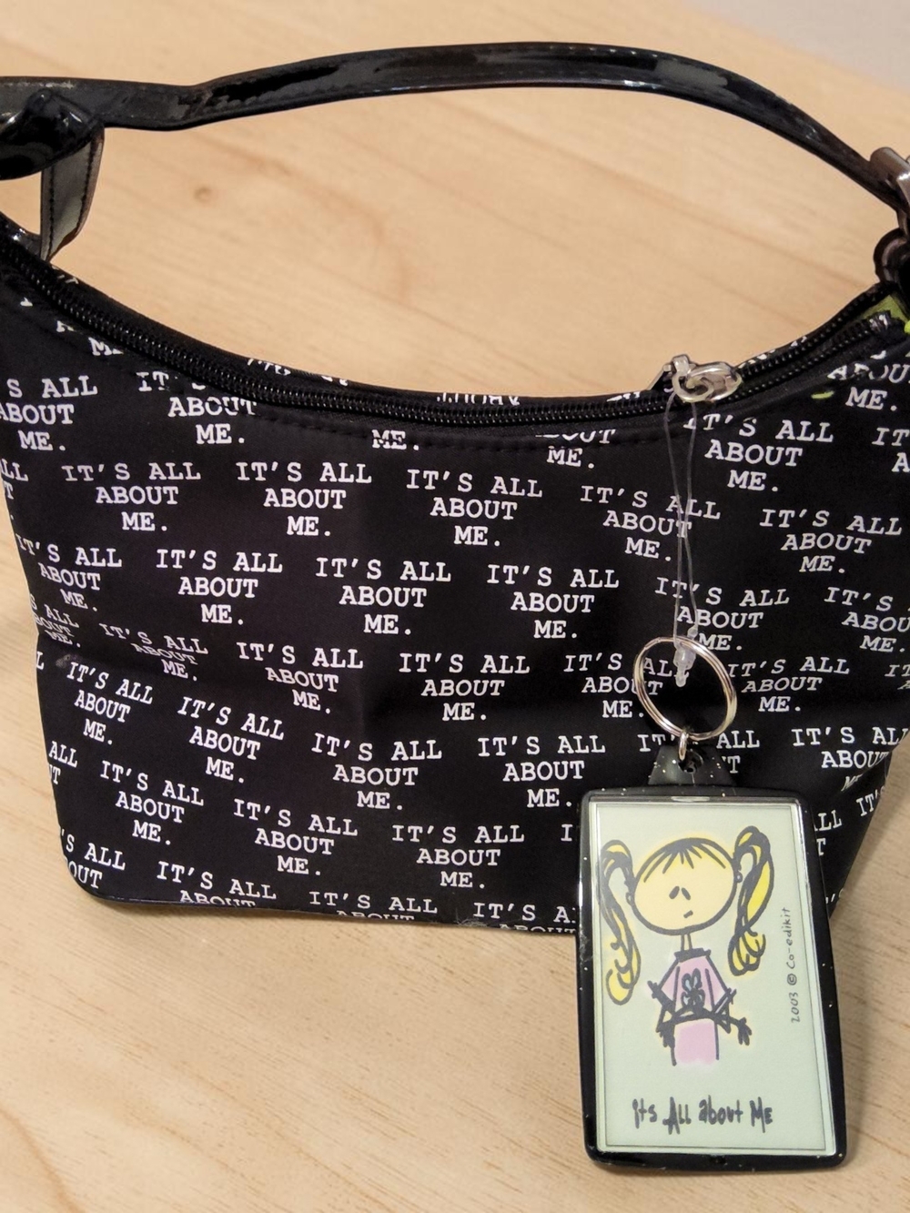 Black Shoulder Bag with 'It's All About Me' Print and Character Charm